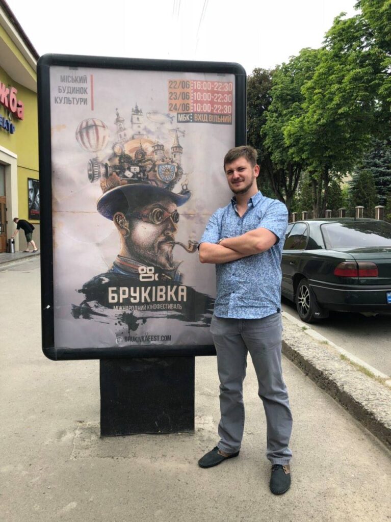 Андрій Заєць біля сітілайта з рекламою фестивалю у Кам'янці-Подільському.